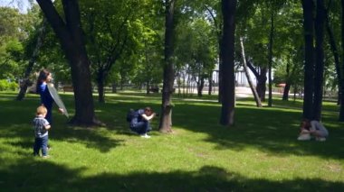 Fotoğrafçı çocuklu annenin fotoğraflarını çekiyordu. Şehir Parkı 'nda sahne arkası fotoğraf çekimi. 2x Ağır çekim 1 / 2 60 FPS