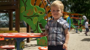 Küçük Çocuk, annesiyle şehir parkında oyun oynuyor. Kentsel Eğlence Yeşil Alanı. Bahar Yaz Güneşli Günü. 2x Ağır çekim 1 / 2 60 FPS