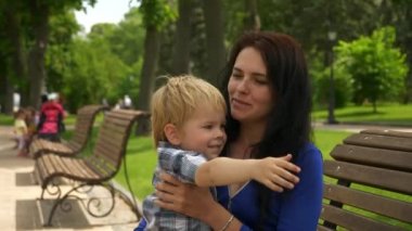 Anne, yaya köprüsünden şehir çevresini gösteren bir kızla konuşuyor. Parlak Yaz Güneşli Günü