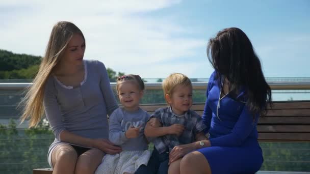 Happy Friends Mothers Sente Com Crianças Banco Ponte Pedonal Parque — Vídeo de Stock