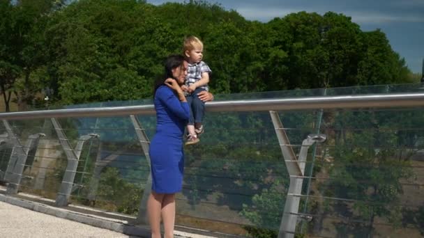 Madre Amantísima Abrazando Niño Cariñoso Mientras Sostiene Las Manos Puente — Vídeos de Stock