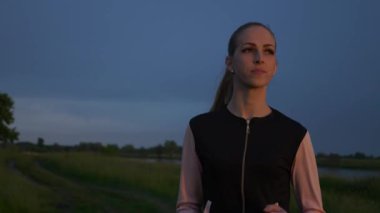 Alacakaranlık 'ta Sunset' in önünde koşan kadın. İyi akşamlar kırsal kesim manzarası. Yağmurlu Bulutlar, Hava Durumu Bahar mevsimi. 2x Yavaş çekim - 60 FPS 'nin 1 / 2 hızı