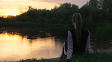 Spor Giyim Kıyafetli Sarışın Kadın Sunset 'i izliyor. Koşu fitnesinden sonra dinleniyorum. 2x Yavaş çekim - 60 FPS 'nin 1 / 2 hızı