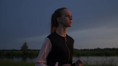 Alacakaranlık 'ta Sunset' in önünde koşan kadın. İyi akşamlar kırsal kesim manzarası. Yağmurlu Bulutlar, Hava Durumu Bahar mevsimi. 2x Yavaş çekim - 60 FPS 'nin 1 / 2 hızı