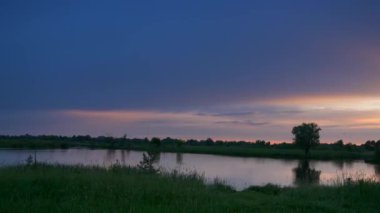 Su yüzeyinde, Nehir Damlaları Üzerinde Günbatımı Yansıması. İyi akşamlar kırsal kesim manzarası. Yağmurlu Bulutlar Hava Mevsimi