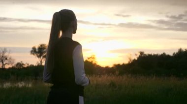 Alacakaranlık 'ta Sunset' in önünde koşan kadın. İyi akşamlar kırsal kesim manzarası. Yağmurlu Bulutlar, Hava Durumu Bahar mevsimi. 2x Yavaş çekim - 60 FPS 'nin 1 / 2 hızı