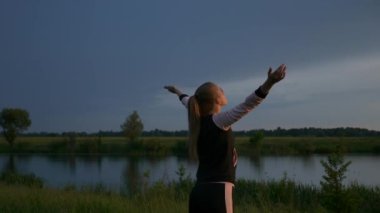 Spor Giyim Kıyafetli Sarışın Kadın Sunset 'i izliyor. Koşu fitnesinden sonra dinleniyorum. 2x Yavaş çekim - 60 FPS 'nin 1 / 2 hızı