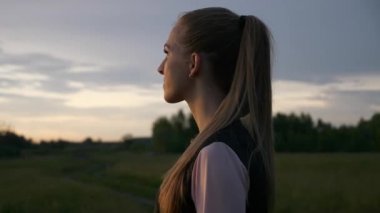 Spor Giyim Kıyafetli Sarışın Kadın Sunset 'i izliyor. Koşu fitnesinden sonra dinleniyorum. 2x Yavaş çekim - 60 FPS 'nin 1 / 2 hızı