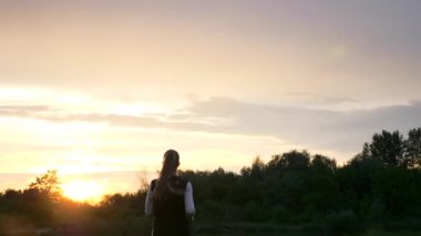 Alacakaranlık 'ta Sunset' in önünde koşan kadın. İyi akşamlar kırsal kesim manzarası. Yağmurlu Bulutlar, Hava Durumu Bahar mevsimi. 2x Yavaş çekim - 60 FPS 'nin 1 / 2 hızı
