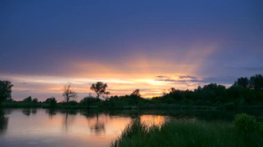 Su yüzeyinde, Nehir Damlaları Üzerinde Günbatımı Yansıması. İyi akşamlar kırsal kesim manzarası. Yağmurlu Bulutlar Hava Mevsimi