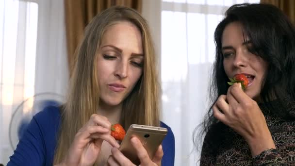Két Női Barátok Esznek Epret Miközben Csevegés Megosztása Néz Közösségi — Stock videók