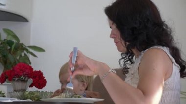 Genç Mutlu Aile, Mutfak Masası 'nda yemek yiyor. Lezzetli Sağlıklı Yemek yemek. 2x Yavaş çekim - Yarım hız 60 FPS