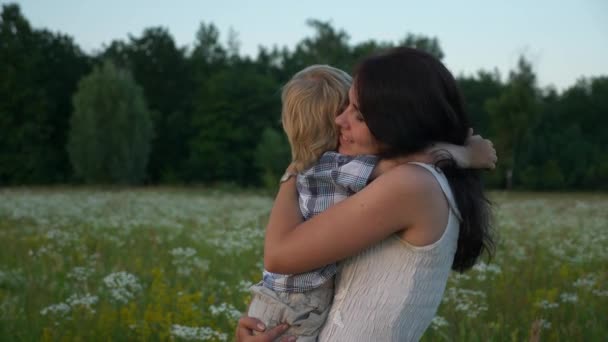 かわいい息子を抱きしめる母を愛する幸せ 美しい自然の中で家族の休息 日没の太陽ビームフレア 夜の田園風景 2倍スローモーション ハーフスピード60 Fps — ストック動画