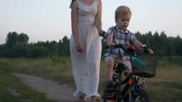 Little Boy Learns Riding Children Bike Assisting Young Mother Strolling — Stock Video