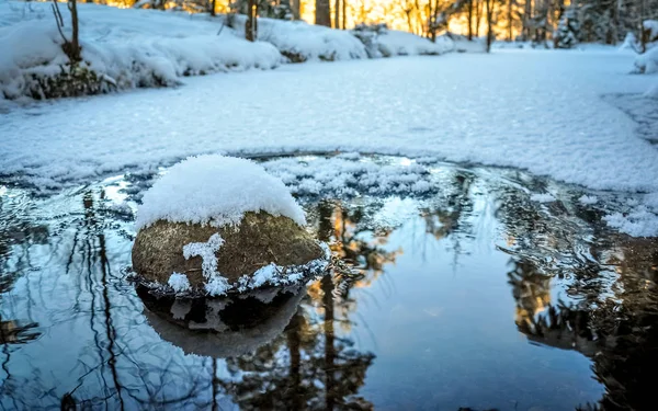 Snow-covered stone in the freezing water stream — Stock Photo, Image