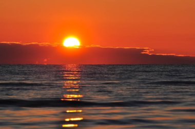 Ladoga şafakta. Dalgalar halinde yansıtan göl üzerinde yükselen güneş