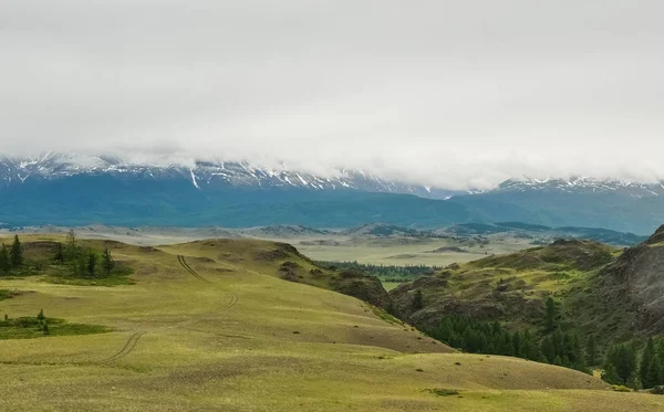 Sommets enneigés derrière les collines boisées . — Photo