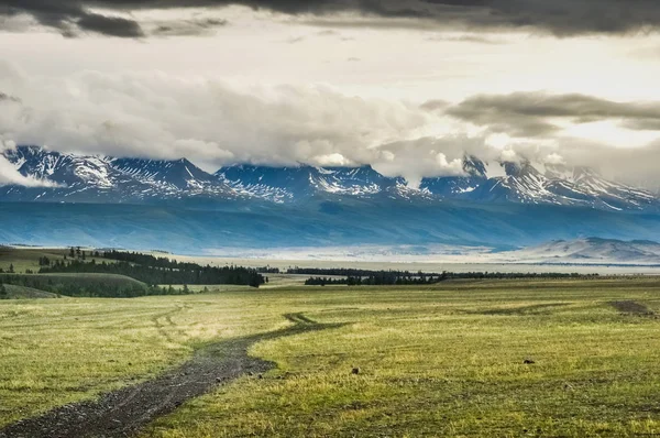 Road in the mountains. Mountain peaks behind the plain. Altai, Siberia — Stock Photo, Image