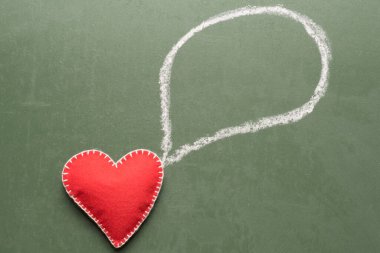 Tebeşirle yazı tahtası yeşil arka planda. Kırmızı kalp