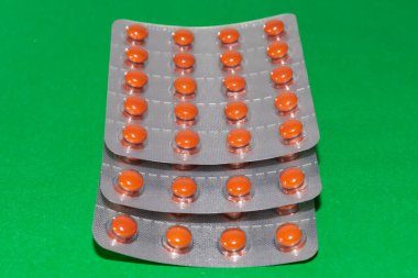 Yeşil arka planda turuncu haplar.