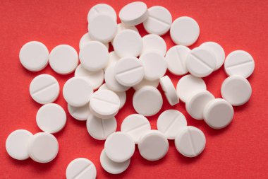 Kırmızı arka plana dağılmış beyaz tabletler