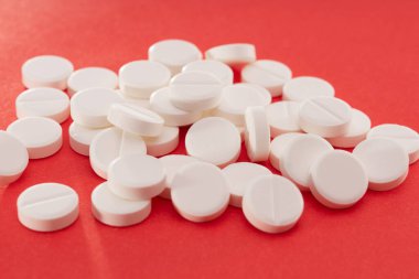 Kırmızı arka plana dağılmış beyaz tabletler