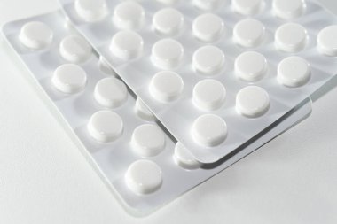 Beyaz arkaplana dağılmış beyaz tabletler