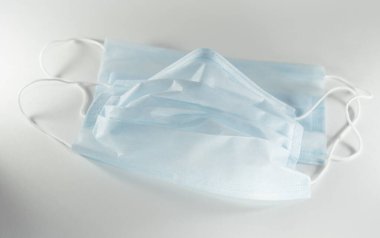 Beyaz arka planda tek kullanımlık mavi tıbbi maske..