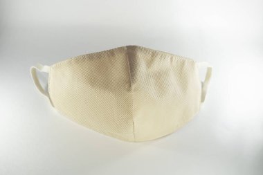 Beyaz arka planda bej yeniden kullanılabilir tıbbi maske.