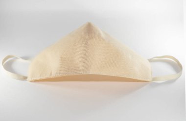 Beyaz arka planda bej yeniden kullanılabilir tıbbi maske.