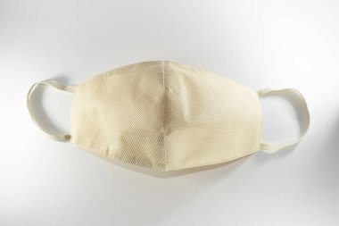 Beyaz arka planda bej yeniden kullanılabilir tıbbi maske.