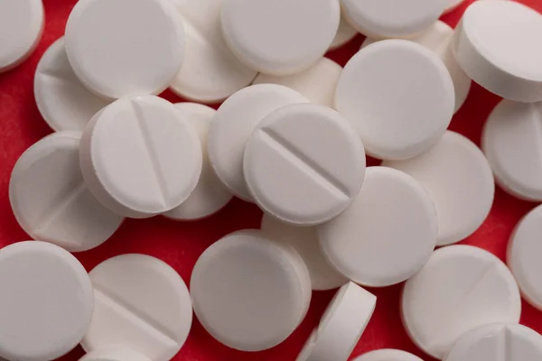 Comprimidos Brancos Espalhados Sobre Fundo Vermelho — Fotografia de Stock