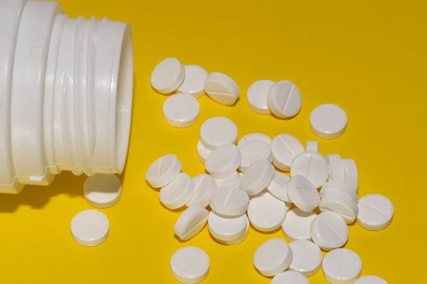 Comprimidos Brancos Espalhados Uma Garrafa Sobre Fundo Amarelo — Fotografia de Stock