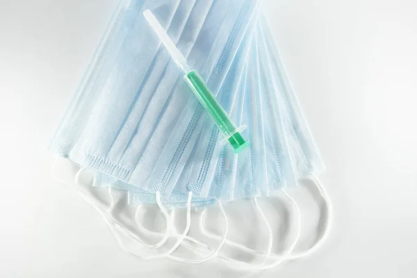 白色背景的一次性蓝色医疗面罩和注射器 — 图库照片