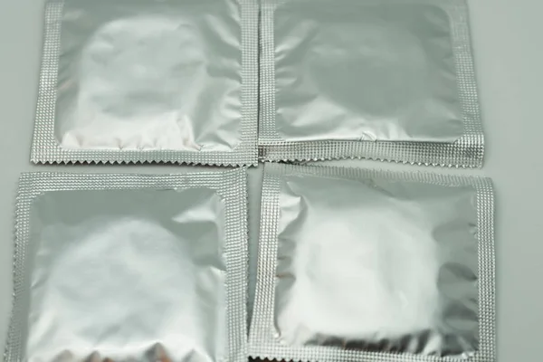 白色背景上的四个密封避孕套 — 图库照片