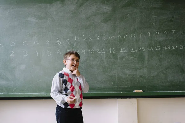 Petit enfant debout au tableau noir en classe — Photo