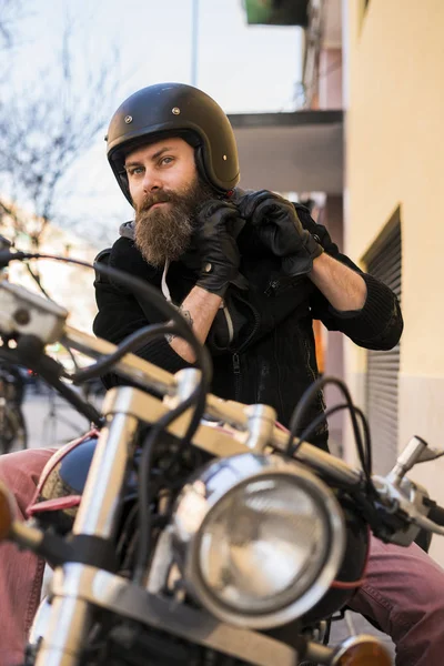 Bearded biker putting on the helmet — Stock Photo, Image