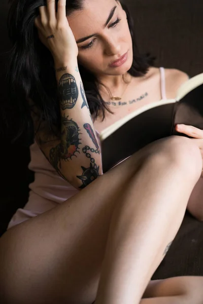 Jeune femme tatouée livre de lecture — Photo