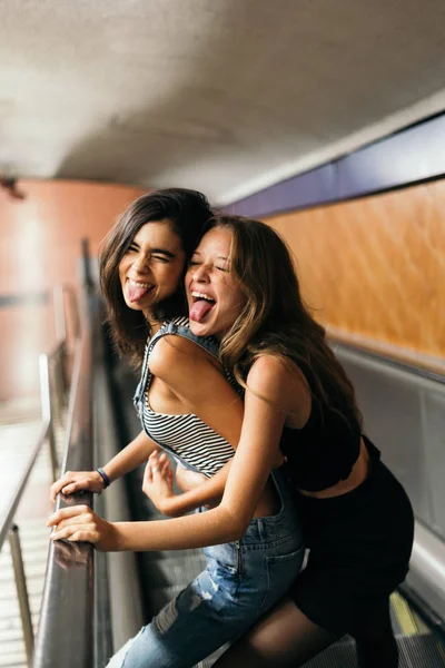 Chicas jóvenes en escaleras mecánicas enloqueciendo —  Fotos de Stock