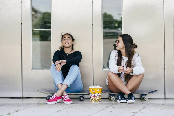 Stylish teens with popcorn on skates — Stock Photo, Image