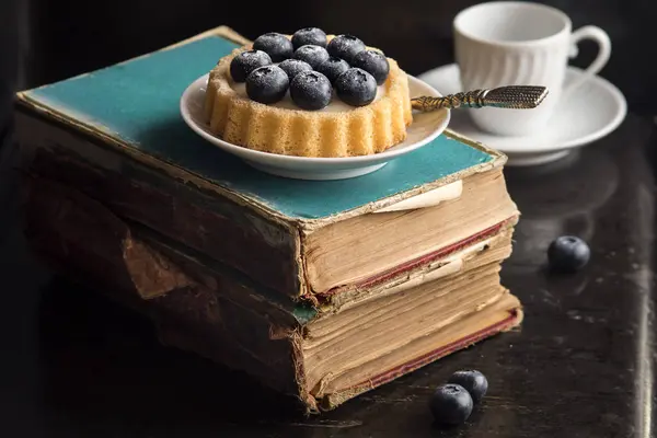 Gâteau aux myrtilles sur de vieux livres — Photo