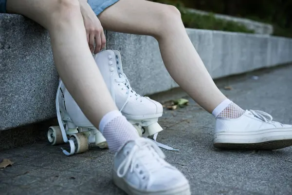 Gewas meisje in sneakers met rolschaatsen — Stockfoto
