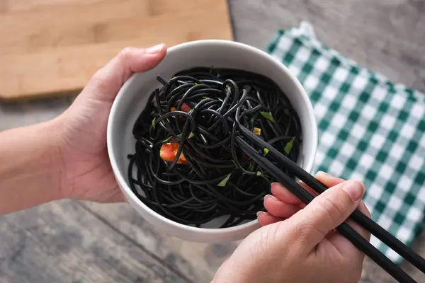 Oříznutí Ruce Držící Misku Černými Špagetami Hůlky — Stock fotografie