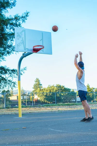 Young man throwing basketball ball — Stock Photo, Image