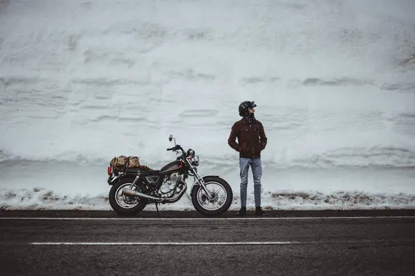 Człowiek Kasku Pozowanie Motocyklem Zaśnieżonej Drodze — Zdjęcie stockowe