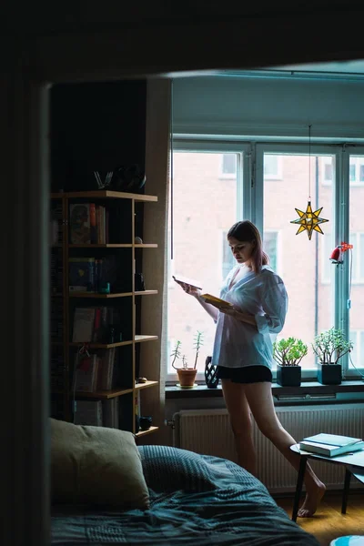 Kadın Evde Pencere Tarafından Gömlek Okuma Kitapta Yan Görünüm — Stok fotoğraf