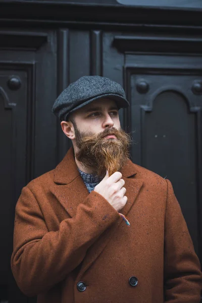 Portrait Thoughtful Bearded Man Stylish Cap Coat Palming Beard Looking — Stock Photo, Image