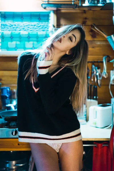 セーターの台所のカウンターのポーズで挑発的な女の子 — ストック写真