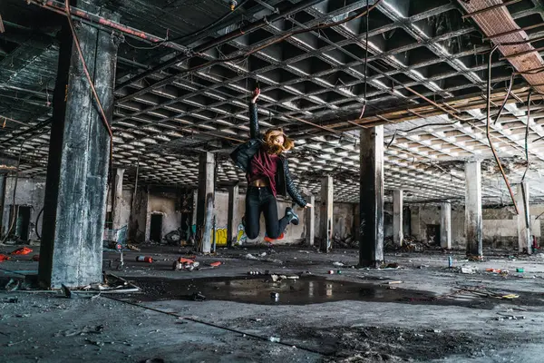 女子跳跃在风化废弃的房间 — 图库照片
