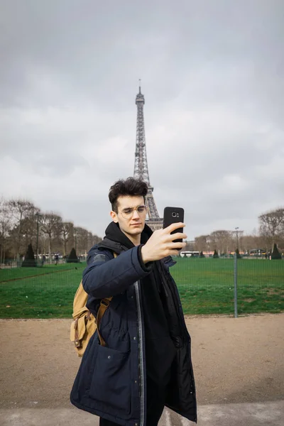 Młody Mężczyzna Stojący Telefonu Biorąc Selfie Tle Wieży Eiffla — Zdjęcie stockowe